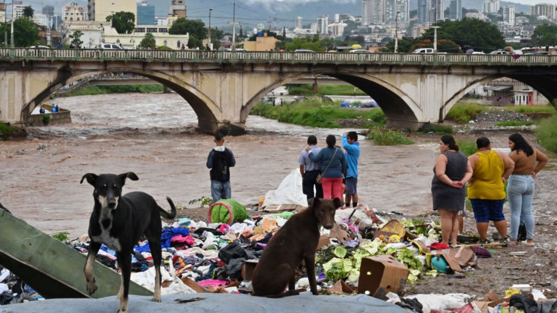 Varias personas observan la crecida del río Choluteca, en Tegucigalpa, el 17 de noviembre de 2024, debido a las fuertes lluvias dejadas por la tormenta tropical Sara.