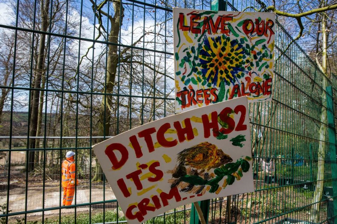 Carteles colocados en una valla por activistas medioambientales protestan contra las operaciones de tala de árboles para el enlace ferroviario HS2 en Jones Hill Wood, en Wendover, Inglaterra, en abril de 2021. Crédito: Mark Kerrison/In Pictures/Getty Images