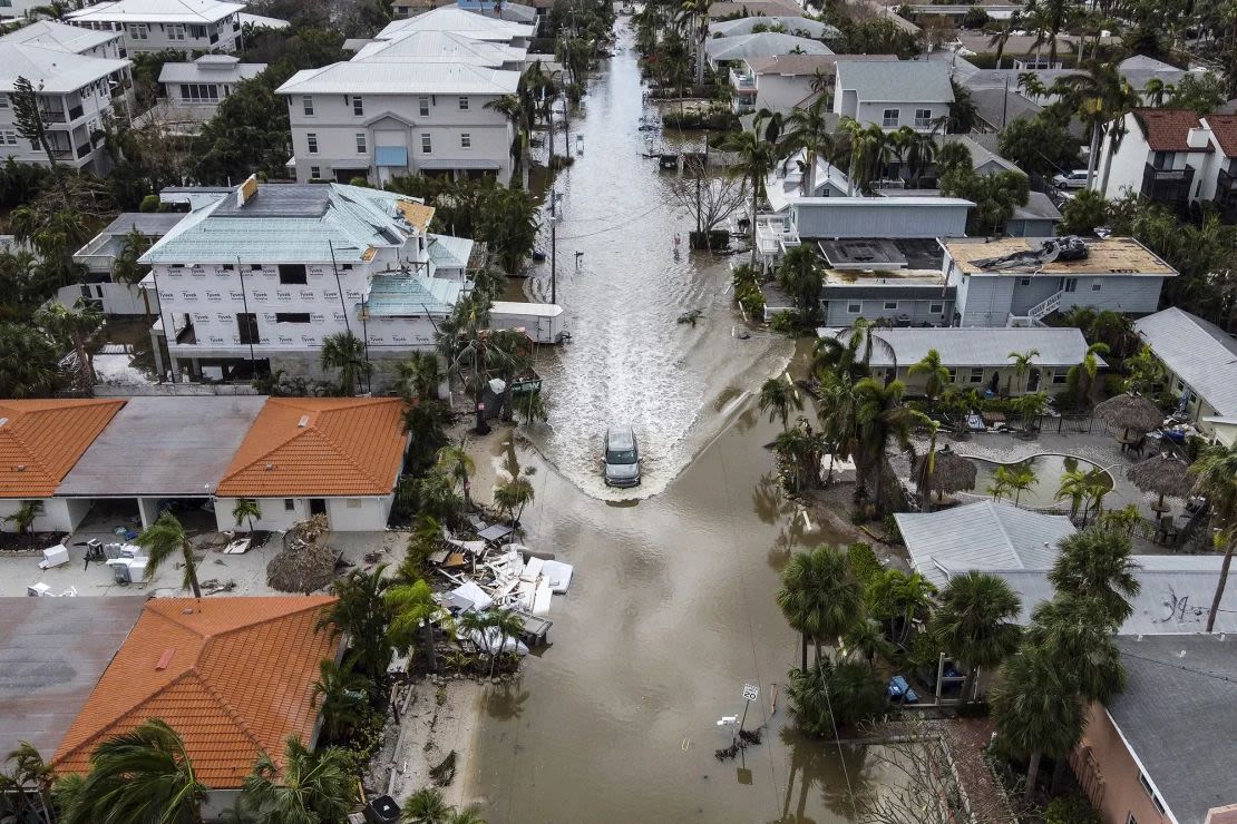 Un vehículo circula por una calle inundada después del huracán Milton, en Siesta Key, Florida, el 10 de octubre de 2024. (Foto: Chandan Khanna/AFP/Getty Images).