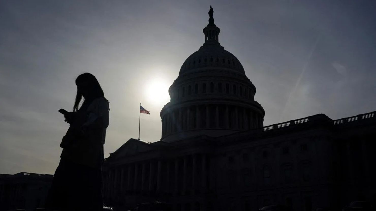 Una persona usa un teléfono con el edificio del Capitolio de Estados Unidos al fondo en Washington, D.C., el 13 de noviembre. Crédito: Nathan Howard/Reuters/Archivo.