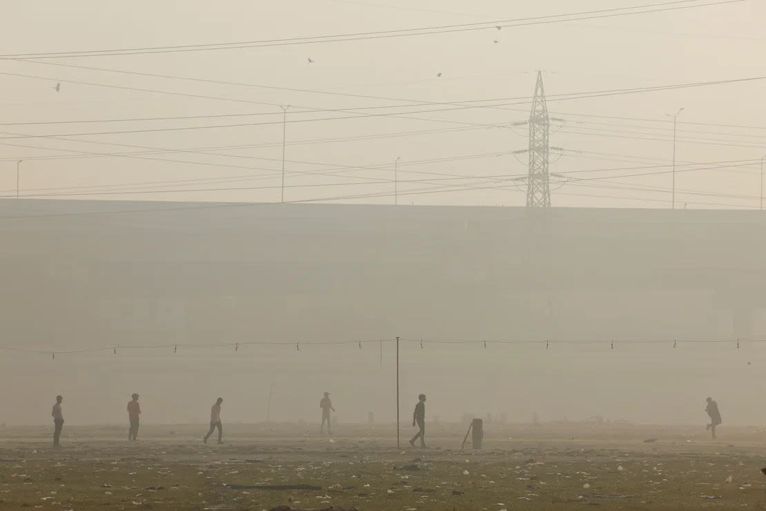 Los hombres juegan al cricket mientras el cielo está envuelto en smog en Nueva Delhi, el 20 de noviembre de 2024.