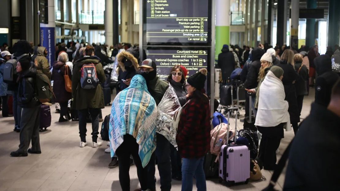 Pasajeros en el exterior de la terminal 4 del aeropuerto de Gatwick mientras un cordón de seguridad rodea la terminal sur. Marcin Nowak/LNP/Shutterstock.