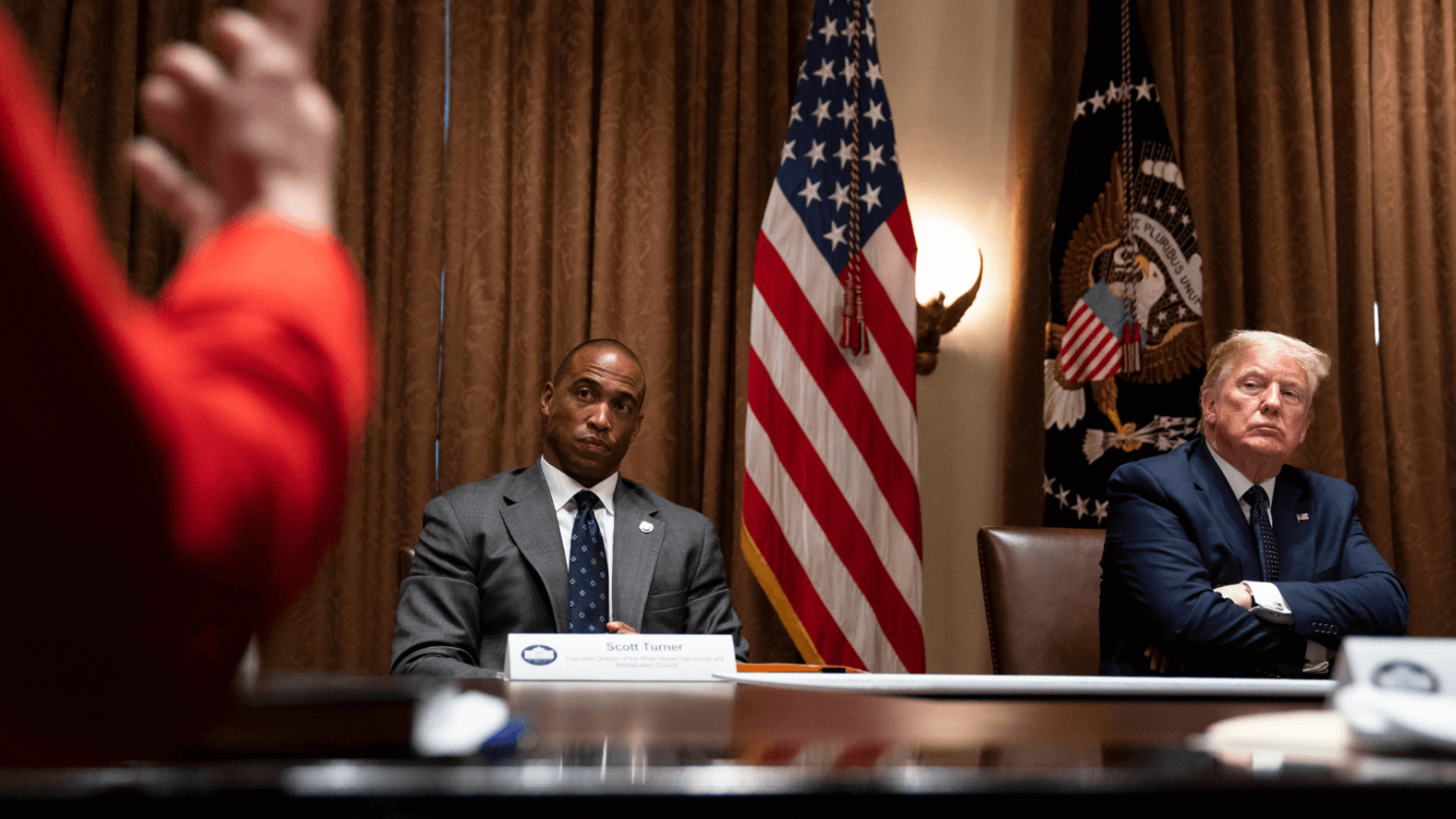 El entonces director ejecutivo del Consejo de Revitalización y Oportunidades de la Casa Blanca, Scott Turner y el presidente Donald Trump escuchan durante una reunión sobre zonas de oportunidad en la Sala del Gabinete de la Casa Blanca, el 18 de mayo de 2020, en Washington.