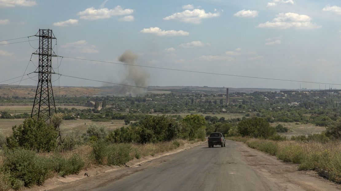 Un vehículo avanza mientras se eleva humo desde la ciudad de Siversk, cerca de la línea del frente en la región oriental de Donetsk.