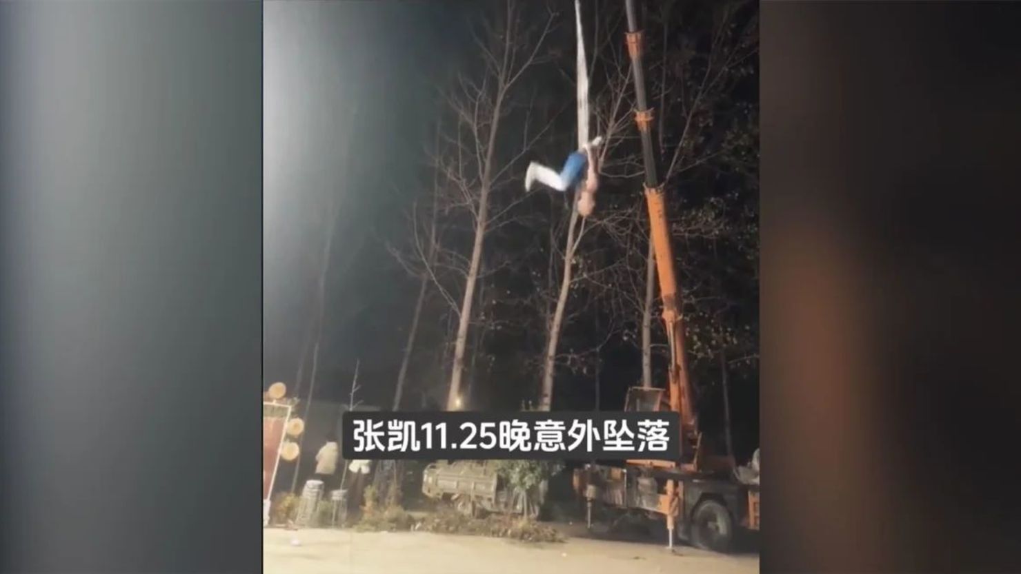 Esta captura de pantalla muestra a Zhang Kai realizando una rutina de seda aérea momentos antes de que la tela se rompiera al soltarse de la grúa.