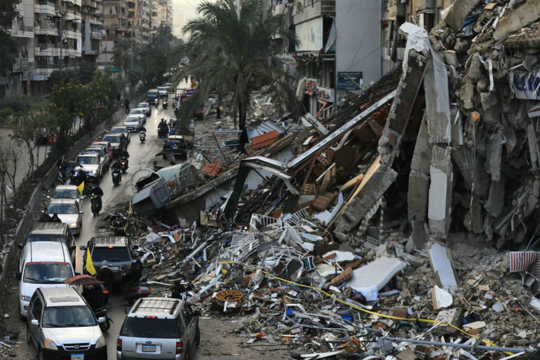 Los automovilistas pasan por un edificio destruido en los suburbios del sur de Beirut el 27 de noviembre de 2024, después de que entrara en vigor un alto el fuego entre Israel y Hezbollah.