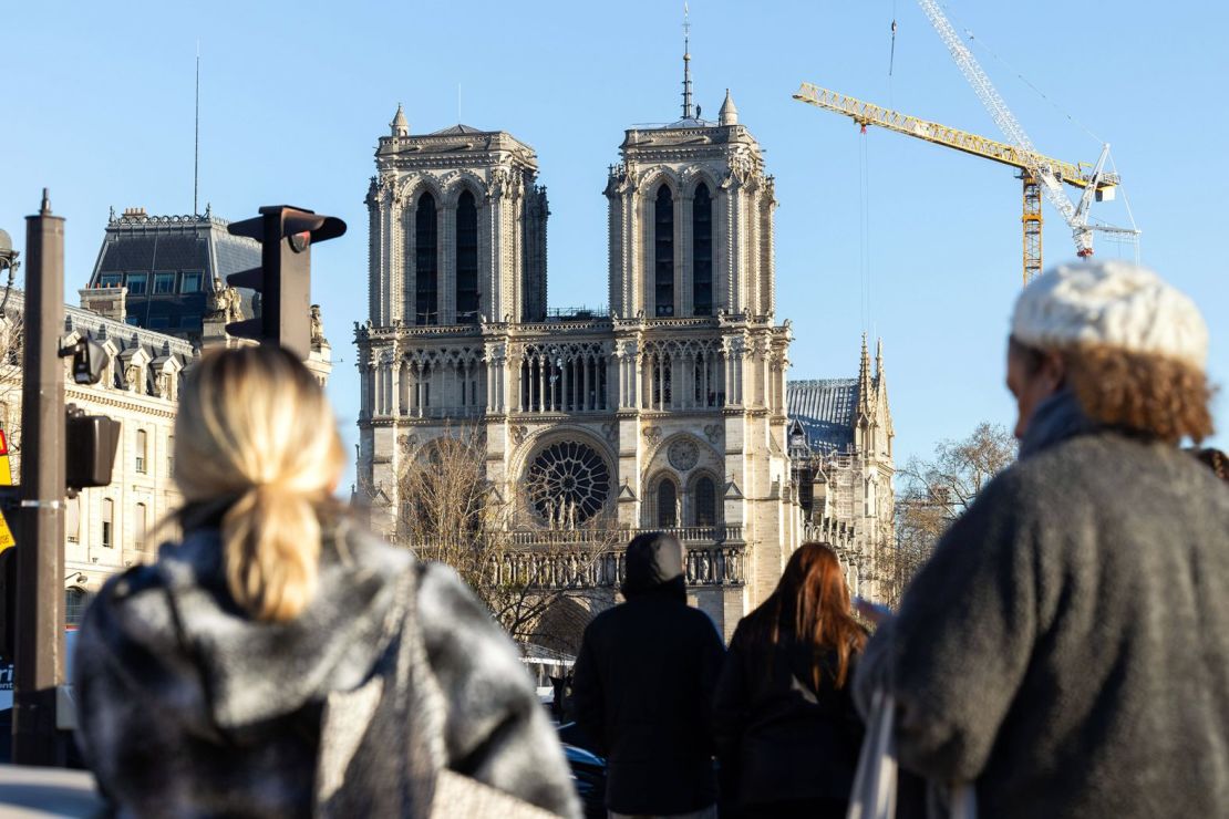 Los peatones se detienen y miran la catedral de Notre Dame el 28 de noviembre antes de la reapertura. (Foto: Thomas Hubert/SIPA/Shutterstock).