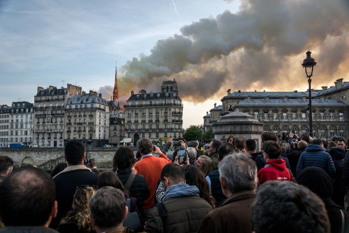 La gente observa cómo se elevan el humo y las llamas durante el incendio en el monumento histórico en el centro de París en abril de 2019. (Foto: Nicolas Liponne/NurPhoto/Getty Images).