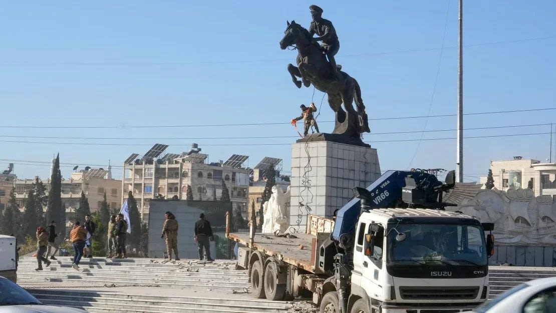 Combatientes rebeldes se preparan para derribar la estatua ecuestre de Bassel al-Assad, el hermano mayor del presidente Bashar al-Assad.