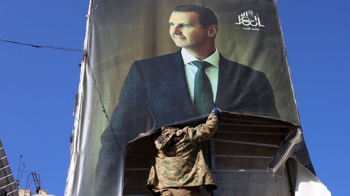 Un combatiente antigubernamental derriba un retrato del presidente sirio Bashar al-Assad en Aleppo, después de que los yihadistas y sus aliados ingresaran a la ciudad del norte de Siria, el 30 de noviembre de 2024.