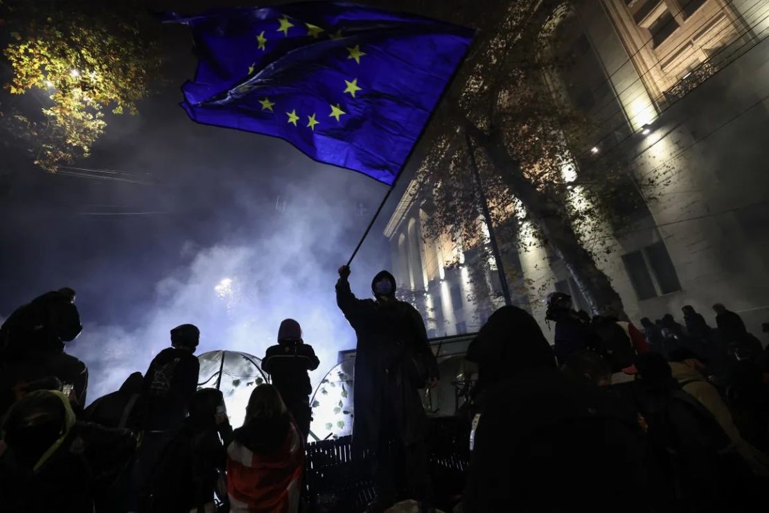 Un activista ondea una bandera de la Unión Europea mientras se manifiesta contra la decisión del gobierno de retrasar las conversaciones de adhesión a la UE, cerca del edificio del Parlamento en el centro de Tiflis el 30 de noviembre de 2024.