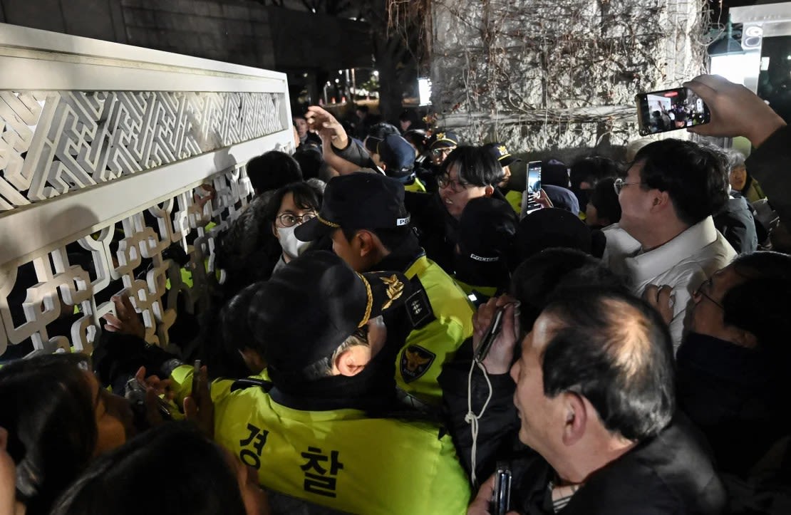 La policía intenta contener a las personas que intentan entrar a la Asamblea Nacional frente a la puerta principal en Seúl el martes por la noche. Jung Yeon-je/AFP/Getty Images