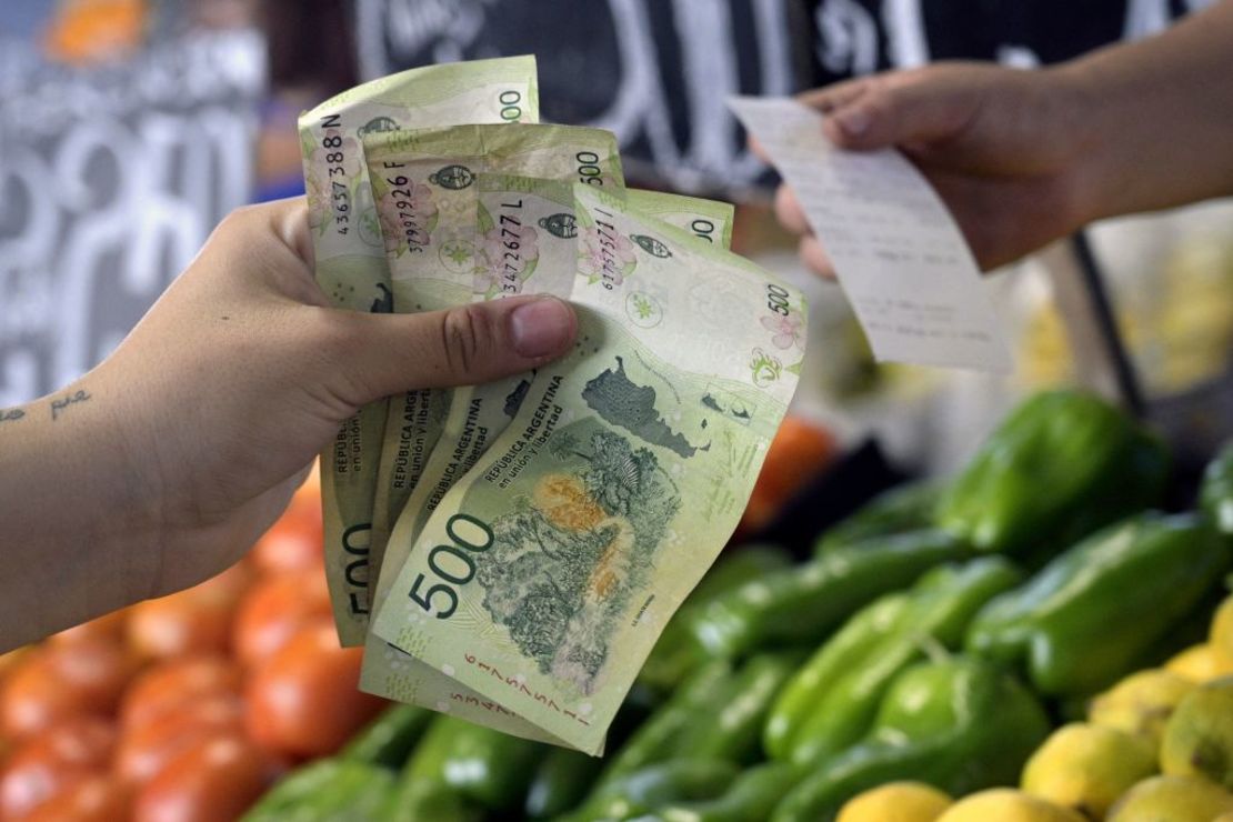 Una mujer paga frutas y verduras en un puesto minorista del Mercado Central de Buenos Aires el 10 de febrero de 2023, unos días antes del anuncio del índice de inflación mensual. (Foto: JUAN MABROMATA/AFP via Getty Images).