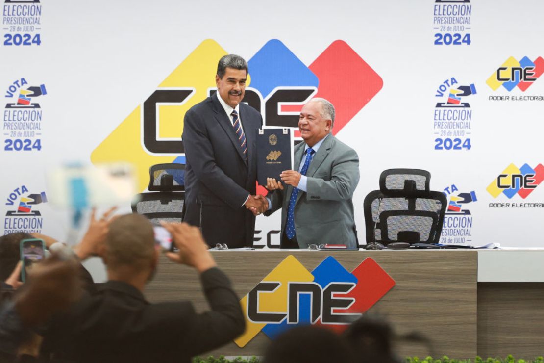 El presidente electo Nicolás Maduro (d) recibe de manos de Elvis Amoroso, presidente del Consejo Nacional Electoral (i) su certificado de proclamación durante la ceremonia de entrega del Certificado de mayoría de votos en la sede del CNE el 29 de julio. Jesus Vargas/Getty Images South America/Getty Images