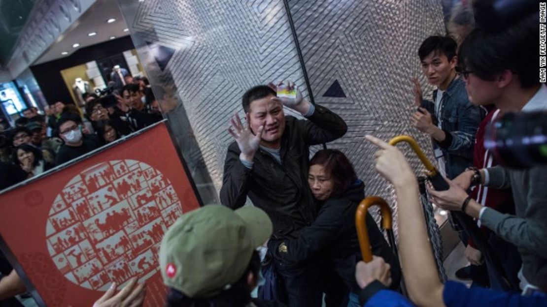 Turistas chinos se ven rodeados por manifestantes en New Town Plaza, un centro comercial en Shatin, Hong Kong, durante una concentración en contra del comercio de productos de mercado paralelo.