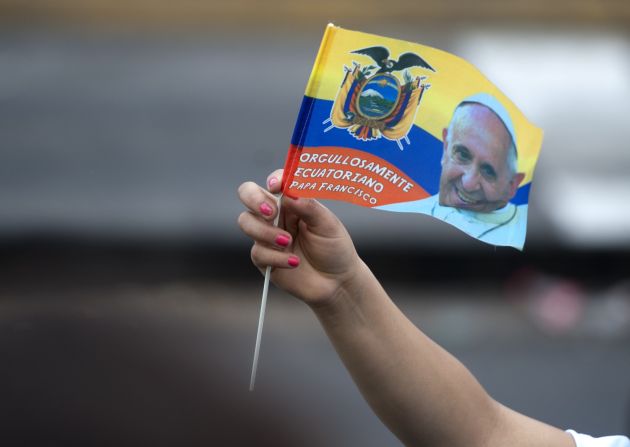 Una mujer ondea una bandera de Ecuador con la foto del papa. Francisco realiza una gira por Sudamérica.