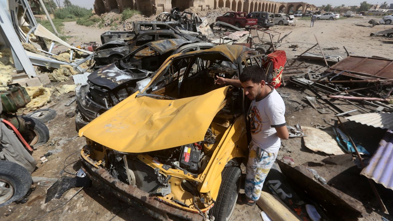 Un hombre observa los daños en un coche por la explosión de un vehículo cargado con explosivos en un mercado de la ciudad de Khan Bani Saad, en Iraq. ISIS reivindicó el atentado suicida.