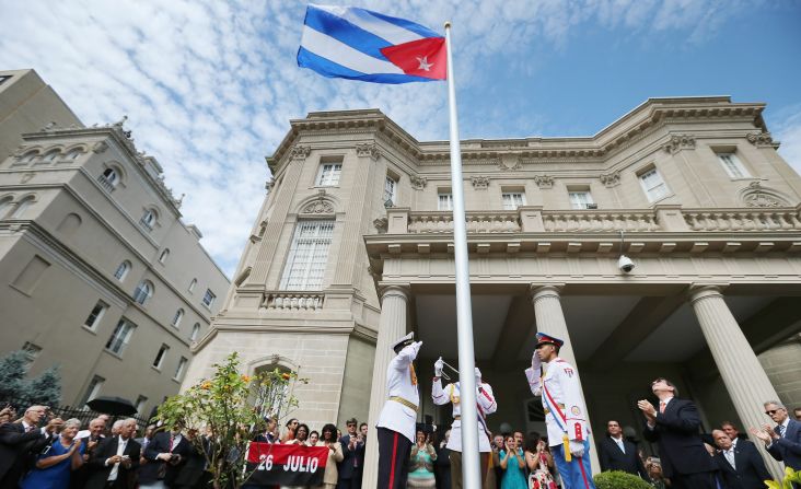 El canciller cubano Bruno Rodríguez aplaude en el momento en que izan la bandera cubana en la embajada en Washington.