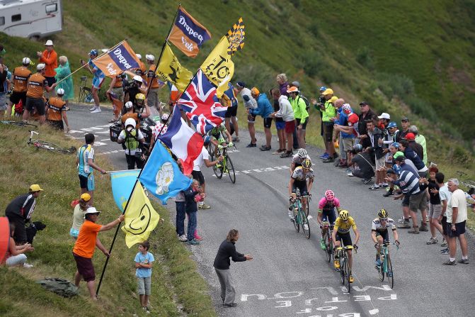 Varios fanáticos del ciclismo ven pasar al grupo líder durante una de las etapas más duras del Tour de Francia.