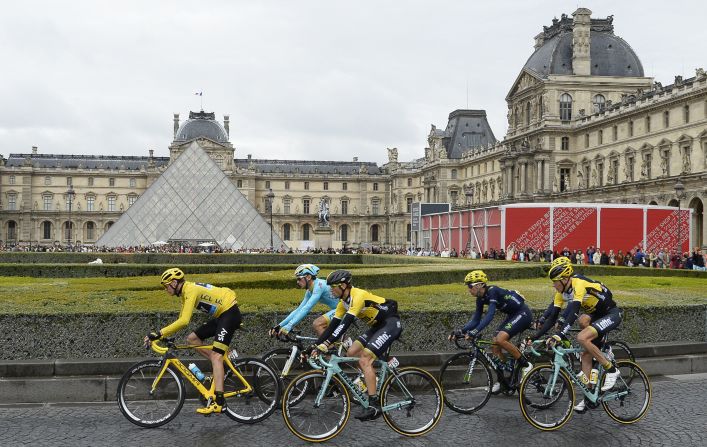 Un pelotón de ciclistas encabezado por el ganador del Tour de Francia 2015, Chris Froome -con el Maillot Amarillo-, circula por el Museo de Louvre de París.