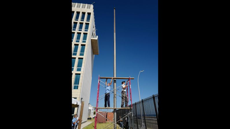 Trabajadores ultiman la colocación del pendón de la bandera afuera del edificio de la Embajada estadounidense, que no figuraba desde 1961. Este viernes, el Secretario de Estado John Kerry presidirá la ceremonia del izamiento de la bandera.