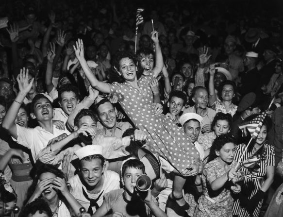 Una mujer sobre la multitud tiene una inscripción en su mano de "V.J. Day".