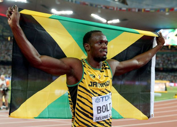 Usain Bolt, el hombre más veloz del mundo, levanta la bandera de Jamaica, durante el Mundial de Atletismo de Beijing.