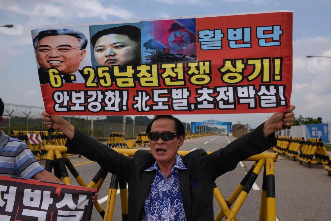 Un hombre protesta contra Corea del Norte y sostiene un cartel en el punto de unificación de la frontera, en la Zona desmilitarizada, el 22 de agosto de 2015.