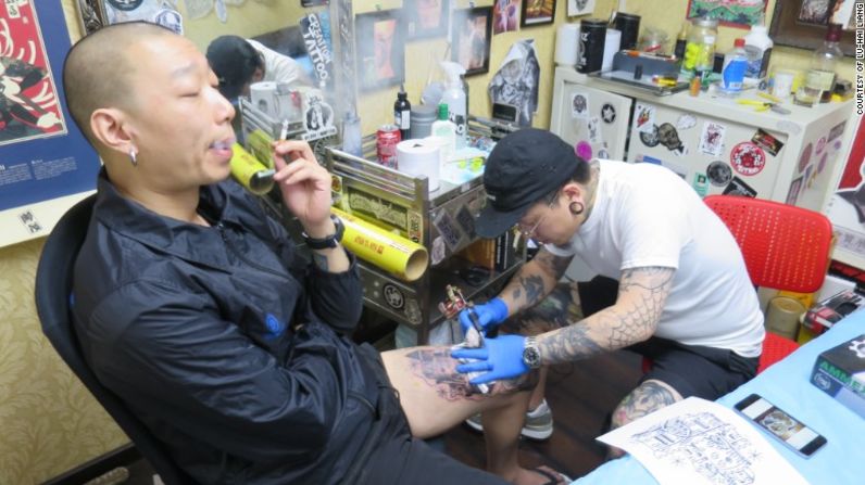 He Wei, de 37 años, es diseñador freelance de Beijing, haciendo un tatuaje. Él dice que sin tatuajes su cuerpo se sentiría muy vacío.
