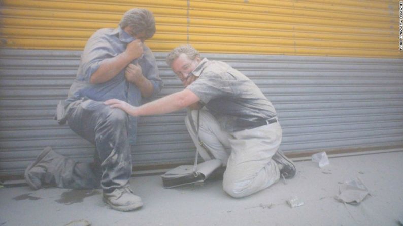 Hombres se cubren mientras que una nube de polvo de las torres derrumbadas envuelve la parte del bajo Manhattan, el 11 de septiembre de 2001.