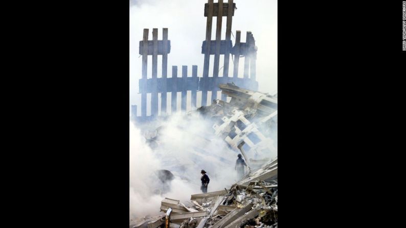 Los bomberos se encuentran entre los restos humeantes del Centro Mundial de Comercio, el 13 de septiembre de 2001.