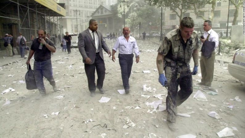 La gente camina por las calles cubiertas de escombros cerca de las torres, el 11 de septiembre de 2001.