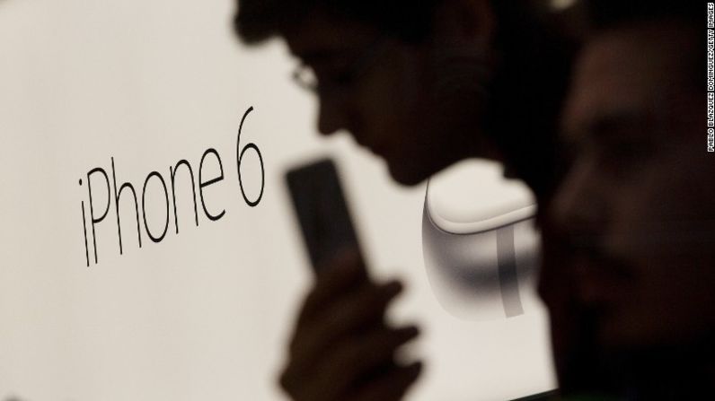iPhone 6 -- 2014 – El Apple amplió el iPhone 6 y presentó un modelo aún más grande, el iPhone 6 Plus. Ambos fueron vistos como intentos de competir con los dispositivos rivales populares de Samsung y de otros fabricantes. Aquí un cliente sostiene su nuevo iPhone 6 el 26 de septiembre del 2014, en una tienda Apple en Madrid, España.