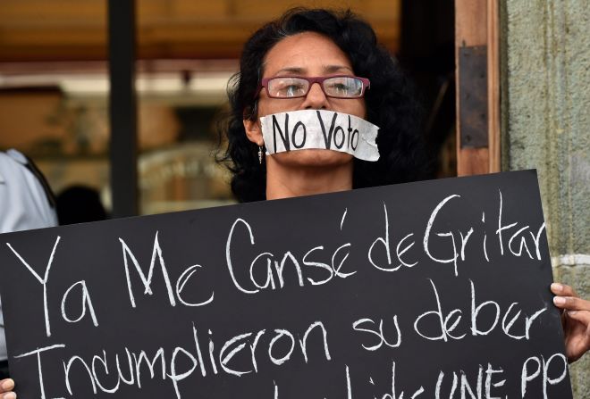 Una manifestante protesta frente al tribunal donde se presenta Otto Pérez Molina después de horas de presentar su renuncia ante el Congreso de Guatemala.