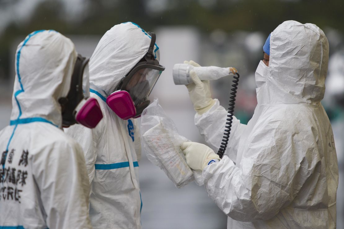 Especialistas protegidos con trajes y mascarillas revisando los niveles de radiación durante los trabajos limpieza en Fukushima, en noviembre de 2011.