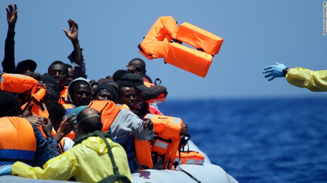 Una embarcación belga lanza salvavidas a un grupo de refugiados en una misión de rescate en el Mediterráneo, en las costas de Libia.