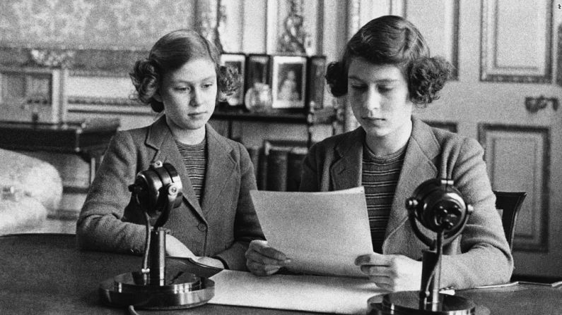 La princesa Isabel, de 14 años (derecha), se sienta cerca a su hermana para una transmisión de radio el 13 de octubre de 1940. En su primera alocución la princesa dijo que los niños de Inglaterra estaban llenos de alegría y coraje.