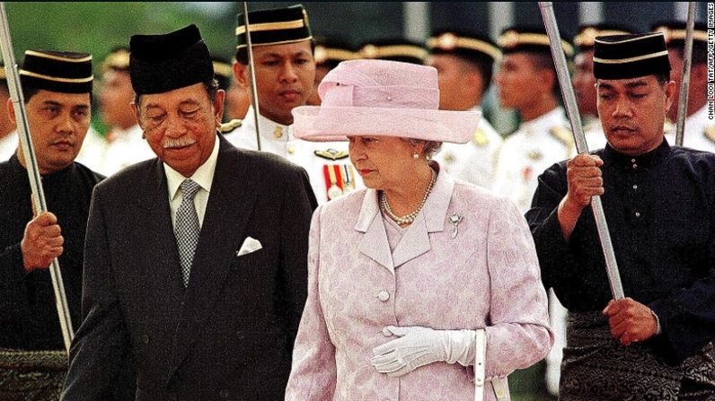 La reina Isabel II es escoltada por el rey Jaafar de Malasia durante una ceremonia de bienvenida oficial en Kuala Lumpur, en septiembre de 1998. Esta visita fue con motivo de la clausura de los XVI Juegos de la Mancomunidad de Naciones (Commonwealth en inglés).