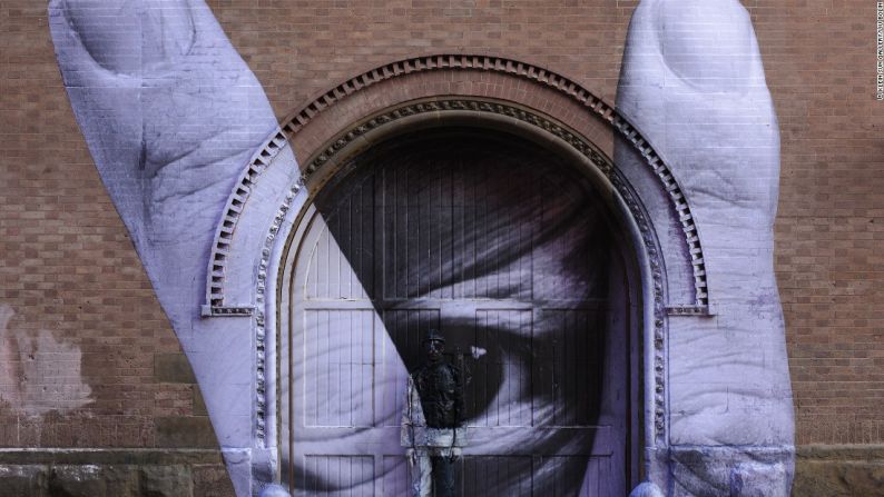 Through the eye of Liu Bolin (2012) - Liu Bolin colaboró con el artista francés callejero JR para este trabajo. Liu se oculta en uno de los murales a gran escala de JR en la ciudad de Nueva York.