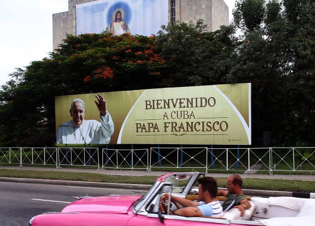 Un auto clásico pasa cerca de la Plaza de la Revolución de La Habana, donde hay varios carteles para darle la bienvenida al papa Francisco.