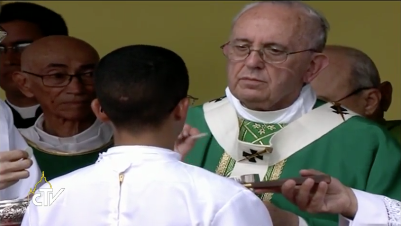 El papa da la comunión a un joven cubano durante la misa en la Plaza de la Revolución.