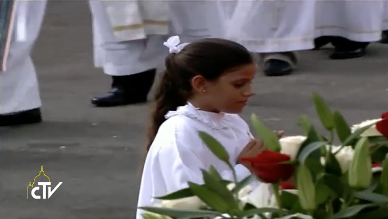 Una niña cubana se dirige hacia el altar para recibir la comunión.