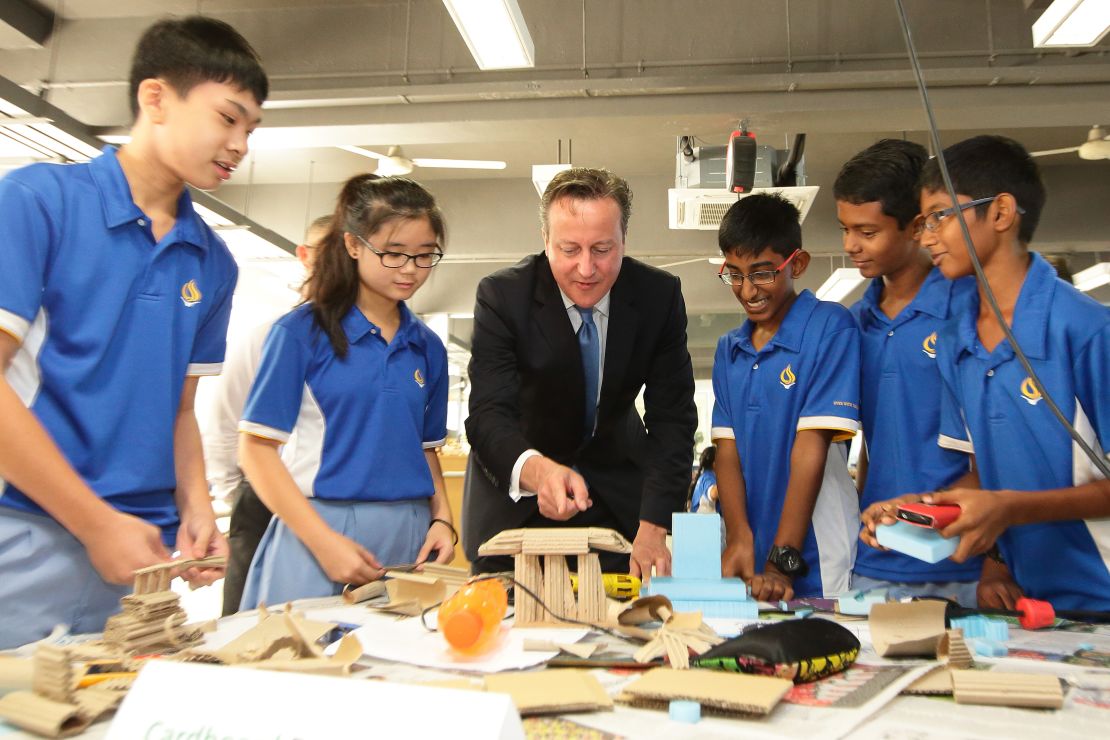 El primer ministro británico David Cámeron interactúa con un grupo de estudiantes de secundaria de Singapur durante una visita oficial a ese país, en julio de 2015.