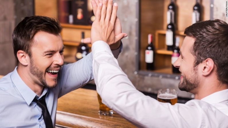 Hombres de negocios borrachines en el bar — A algunos huéspedes les desagrada lo mucho que chocan esos cinco.