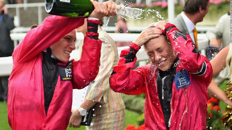 La capitana del equipo femenino, Emma-Jayne Wilson, baña a Bell con champán luego de que la aprendiz ayudara a sellar la primera victoria para un equipo femenino en la competencia anual.