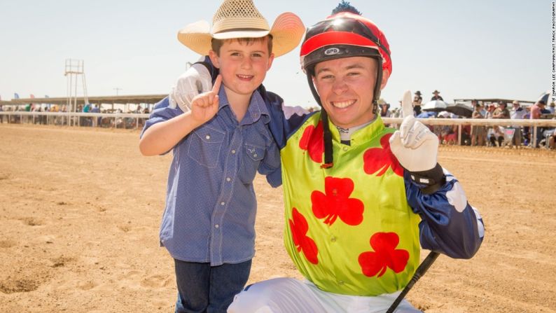 Apoyo a un ganador - Un jockey posa con un joven aficionado antes de la carrera.