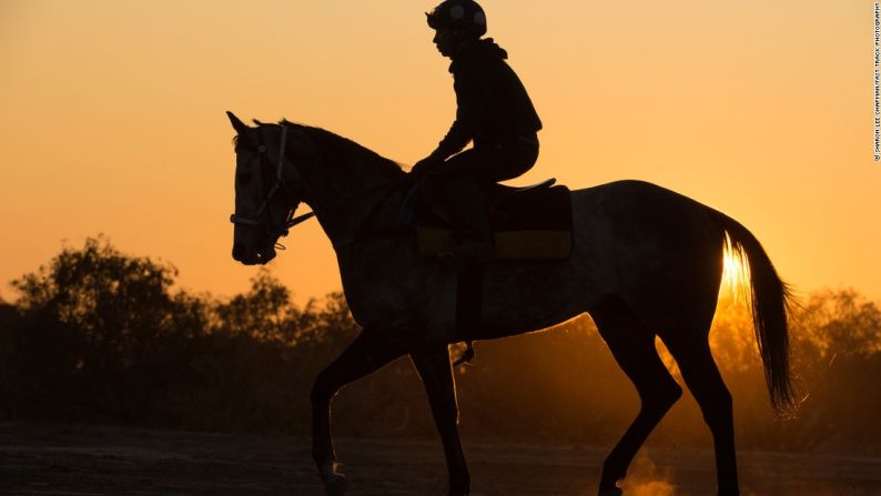 Condado de Orange - El amanecer en Birdsville y un jockey que hace un recorrido temprano en la mañana a modo de preparación para la gran carrera del pueblo. Las carreras de Birdsville se celebraron por primera vez en 1882, entre un puñado de caballos de trabajo, y eran presenciadas por unos cuantos lugareños. Hoy en día, el evento atrae a miles de espectadores para el evento de dos días.