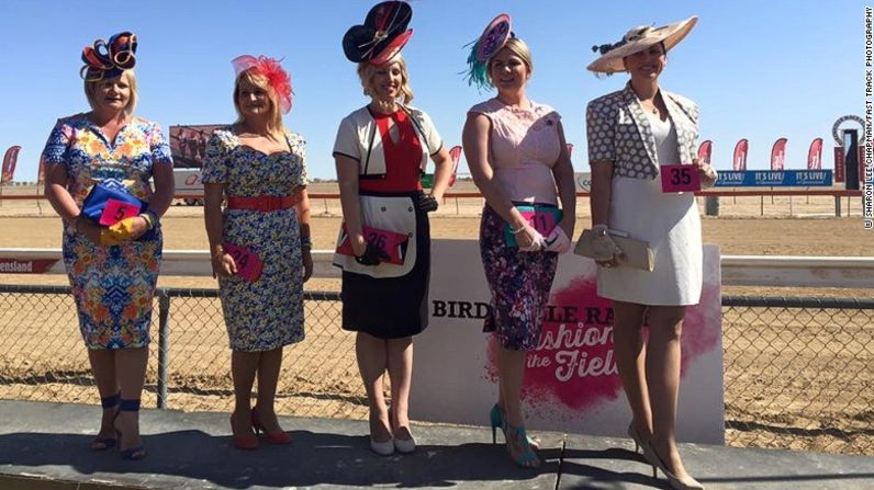 Elegancia - Un grupo de mujeres posa para una fotografía junto a la pista de carreras de Birdsville, un grato toque de color en medio de un mar de maleza y polvo.