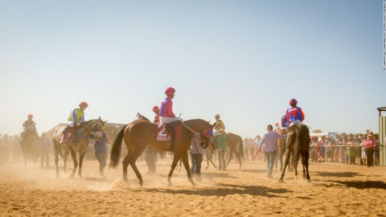 Antes de que todo vuelva a la normalidad - Caballos y jockeys desfilan para los apostadores antes de la gran carrera del sábado.