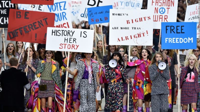 Chanel primavera/verano 2015 – Al cambiar los habituales asientos de primera fila por bancos, los asistentes fueron testigos de cómo Cara Delevingne lideraba un ejército de modelos a través de las "calles" de París, sosteniendo carteles con citas inspiradoras como accesorios.